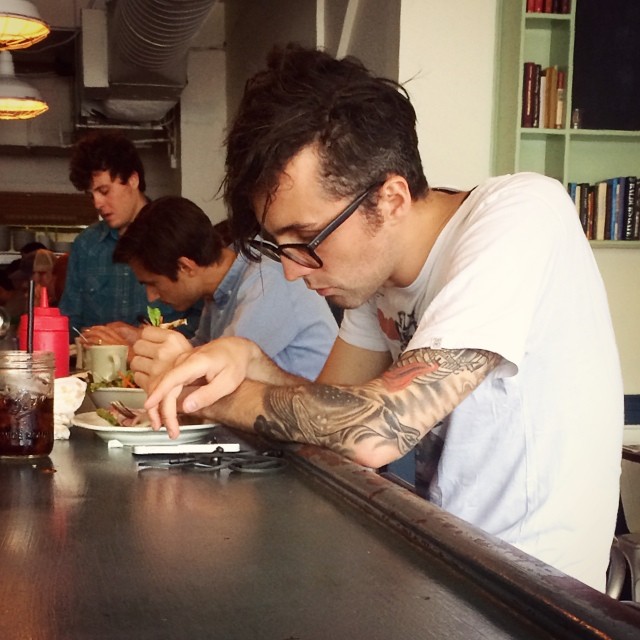 Homme qui écrit un message sur son téléphone au comptoir d'un café
